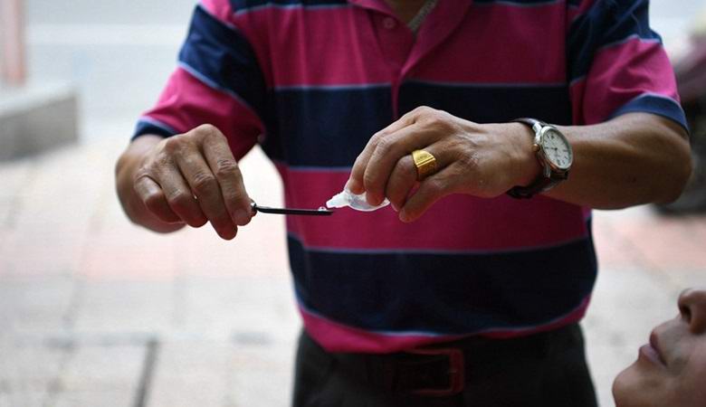 Китайският фризьор успешно обръсва очите на клиентите